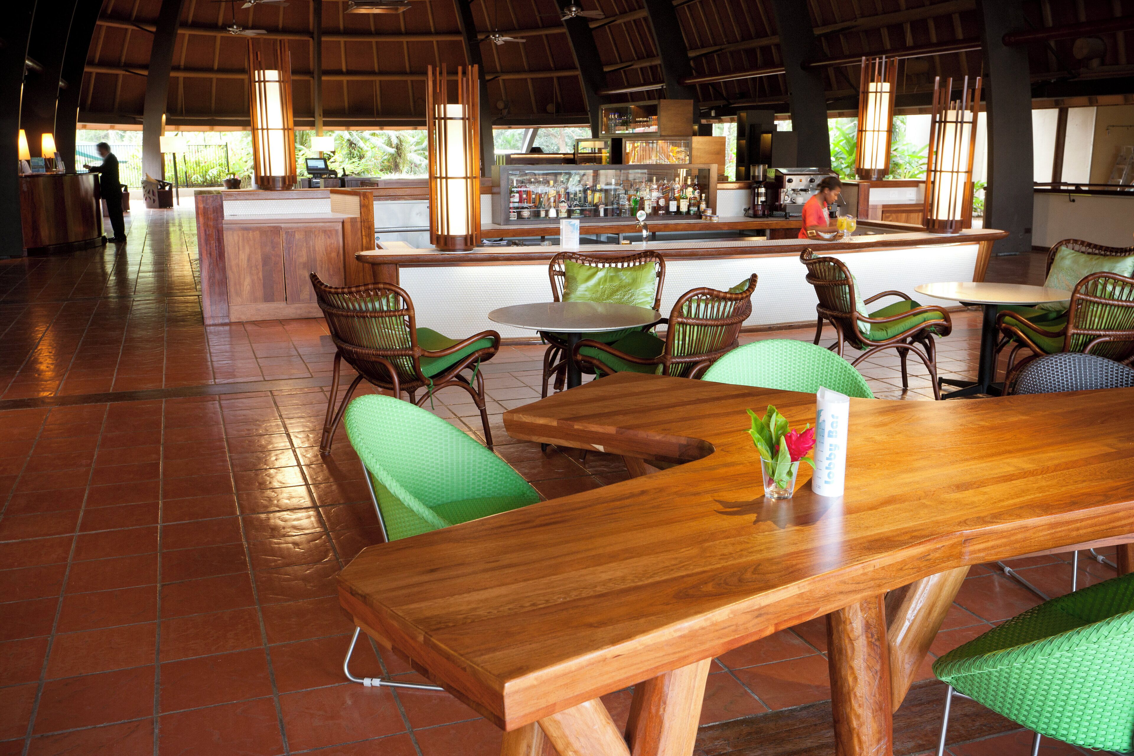A restaurant with wooden furniture, a bar area, and a view of the outdoors.