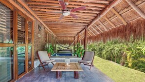 A covered outdoor area with a pool, wooden ceiling, and glass doors. - The Explorean Selva Maya Kohunlich (Kohunlich)