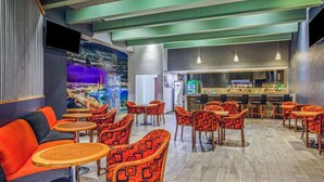 A modern bar area with seating, a bar counter, and a cityscape mural on the wall. - CHN Hotel Monterrey Centro, Trademark by Wyndham (Monterrey)