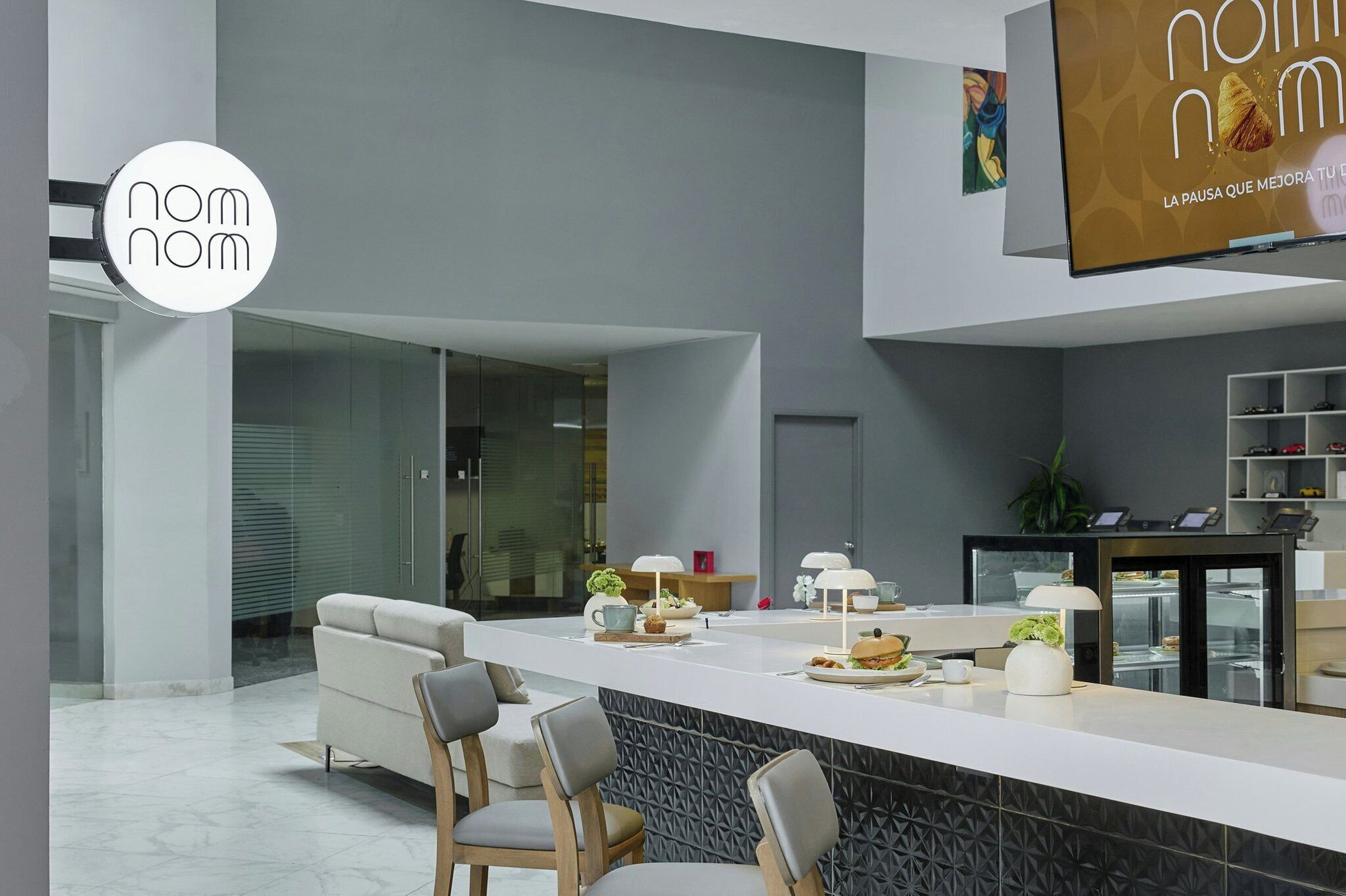 A modern kitchen with a central island, seating area, and a dining table.