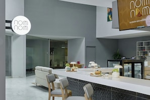 A modern kitchen with a central island, seating area, and a dining table.