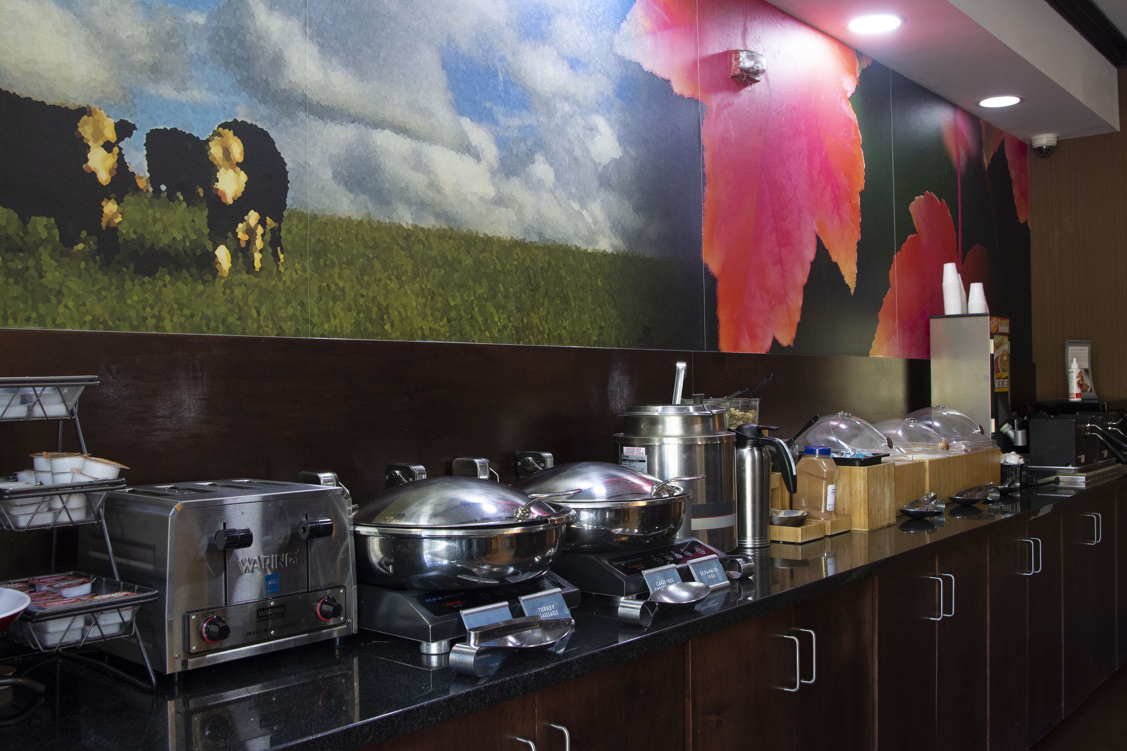 Disposição de buffet com diversos recipientes de comida e uma torradeira Waring.