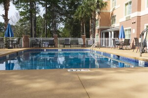 Una piscina al aire libre, sillones reclinables de piscina