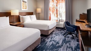 A hotel room with two beds, a desk, a chair, a TV, and a window with curtains. - Fairfield by Marriott Inn & Suites Jacksonville (Jacksonville)