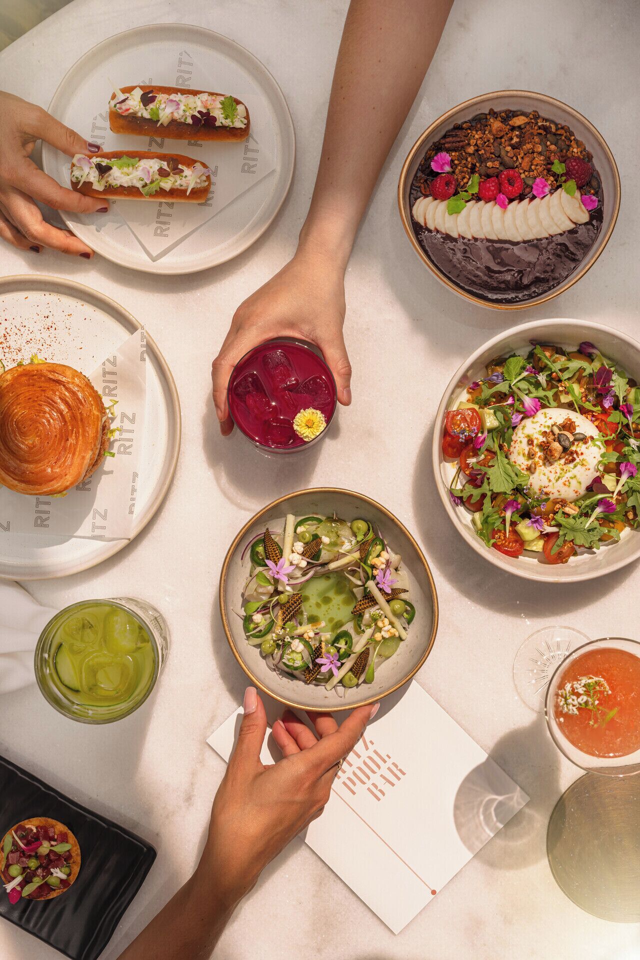A table with various dishes, including a croissant, a salad, and a dessert.