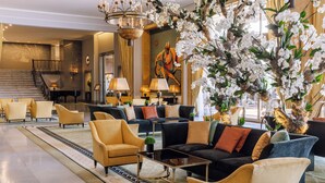 A spacious lobby with a grand chandelier, plush seating, and a large orchid display. - Four Seasons Hotel Ritz Lisbon (Lisbon)
