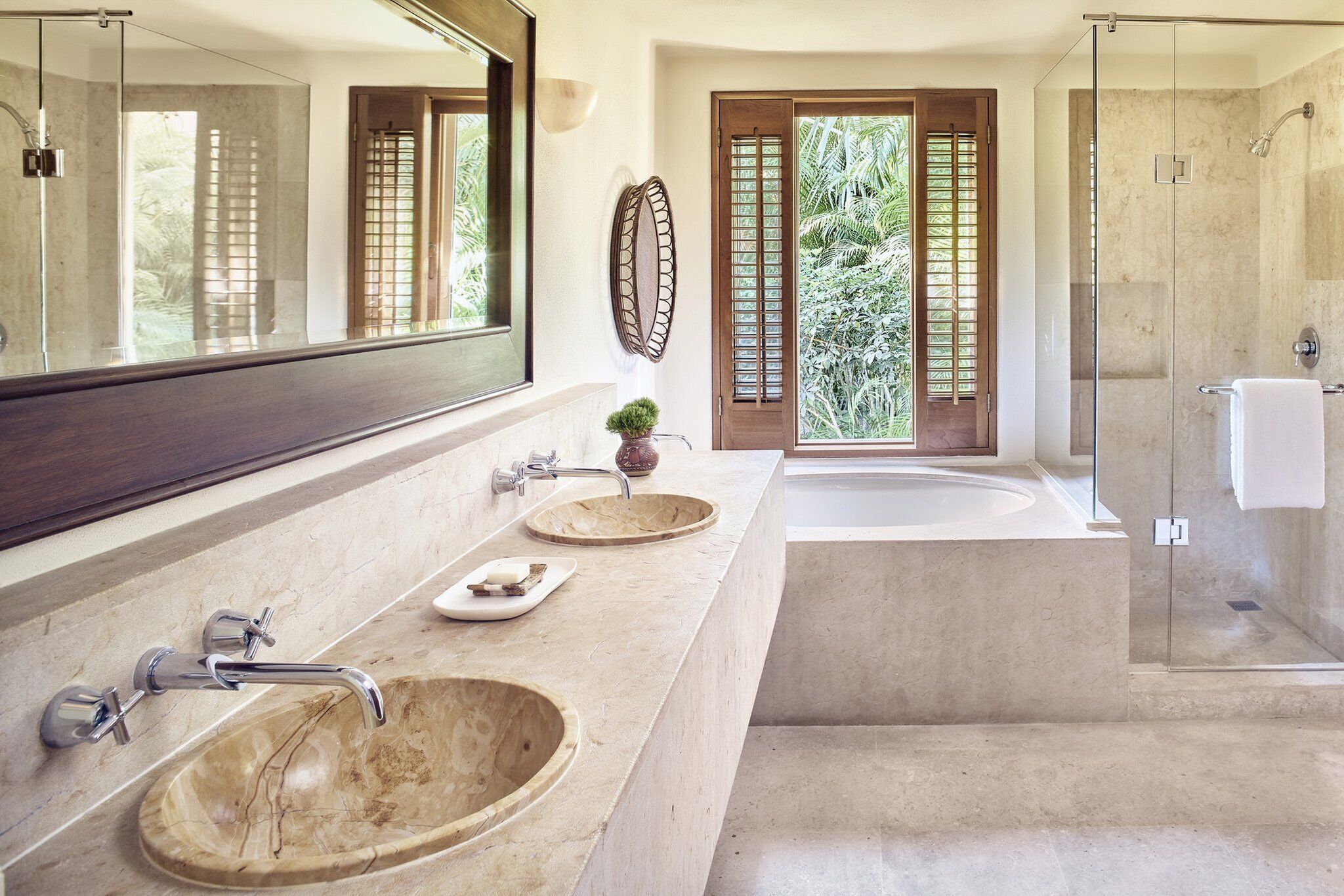A modern bathroom with two sinks, a bathtub, and a glass-enclosed shower.