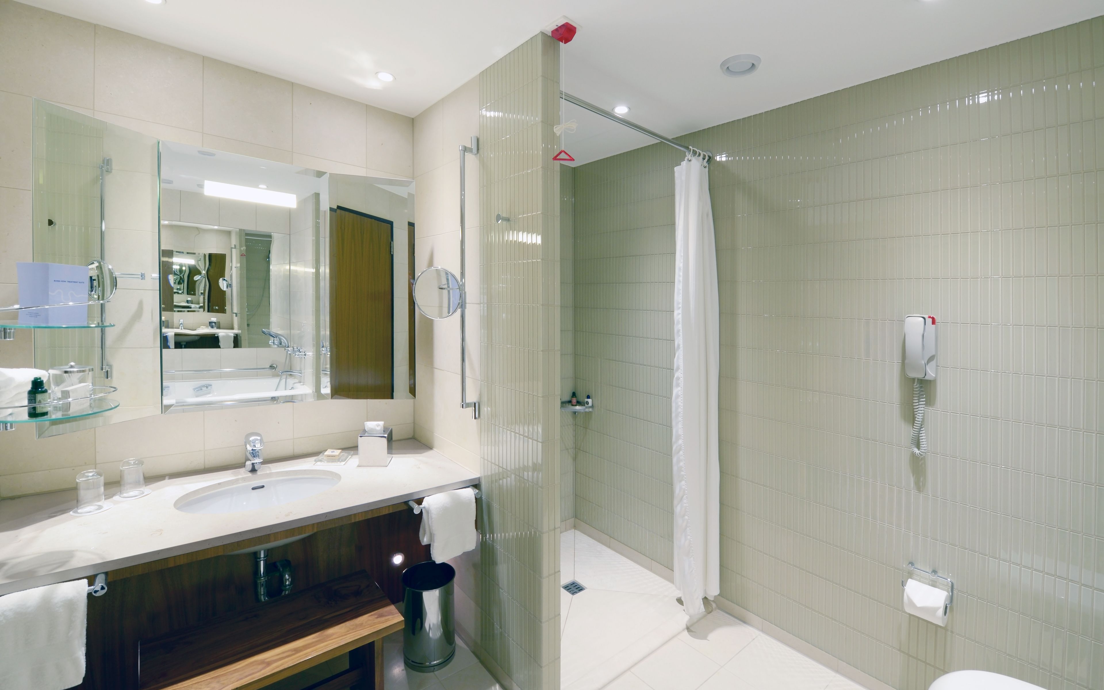 A modern bathroom with a glass-enclosed shower, a vanity with a mirror, and a toilet.