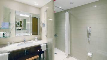 A modern bathroom with a glass-enclosed shower, a vanity with a mirror, and a toilet.