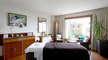 Relax in a spacious room with a large bed, dresser, and mirror, offering a view of the city outside.
