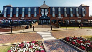 A building with a pub, grill, Starbucks, and Works signs. - Village Hotel Nottingham (Nottingham)