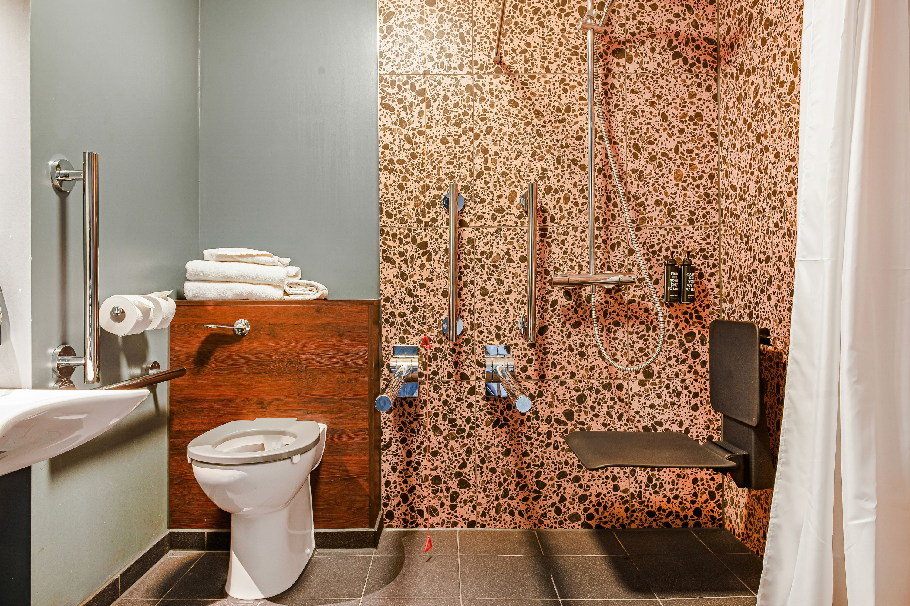 A bathroom with a toilet, sink, and shower area.