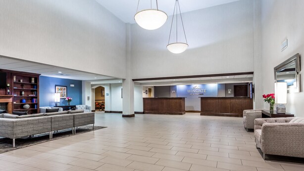 A spacious lobby with a reception desk, seating area, and a bookshelf. - Wingate by Wyndham High Point/Greensboro/Airport South (High Point)