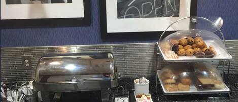 Montaje de buffet con una variedad de productos de panadería y una estación de café.