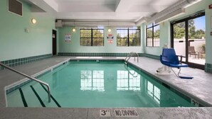 An indoor swimming pool with clear water, a 3-foot no diving sign, and a blue chair on the poolside. - Wingate by Wyndham High Point/Greensboro/Airport South (High Point)