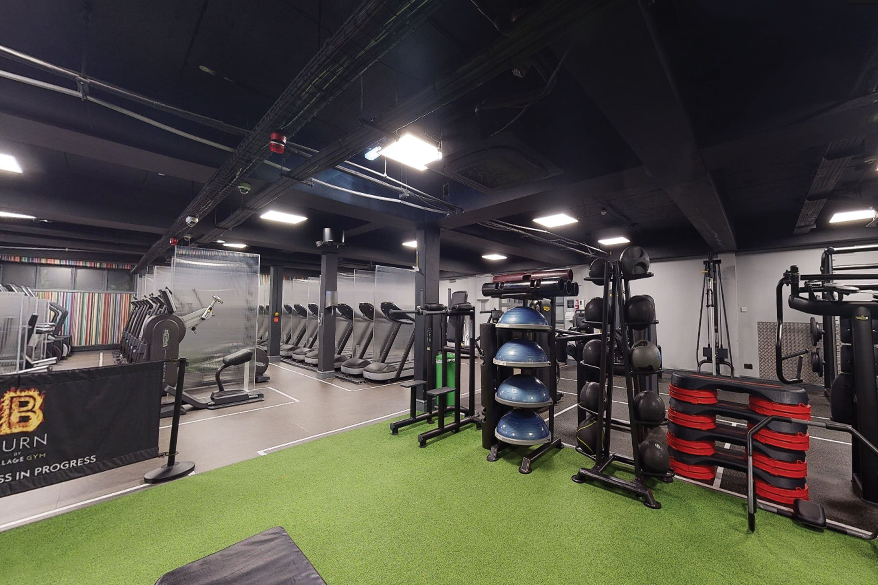 A gym with treadmills, weight machines, and exercise balls.