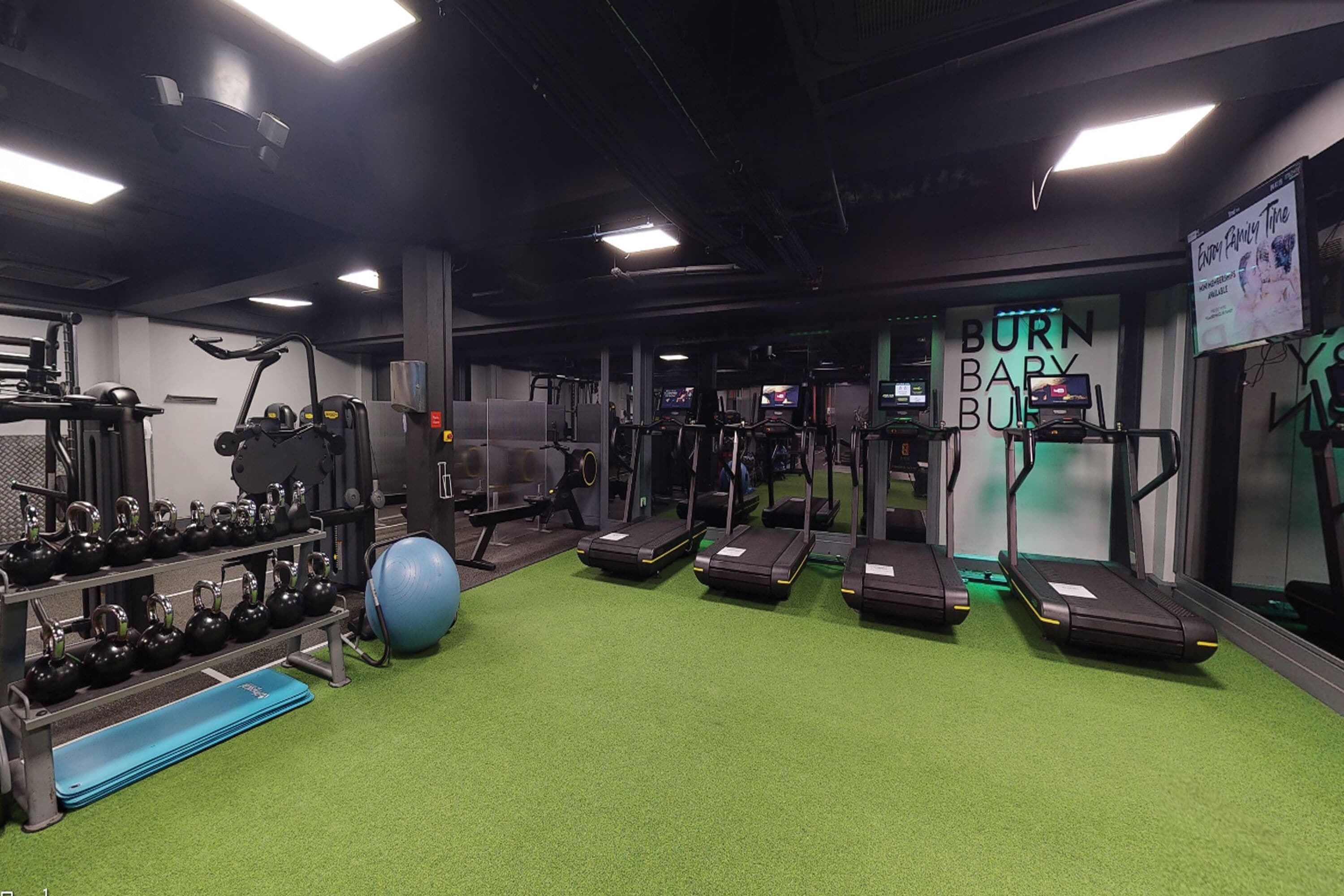 A gym with treadmills, kettlebells, and exercise balls.