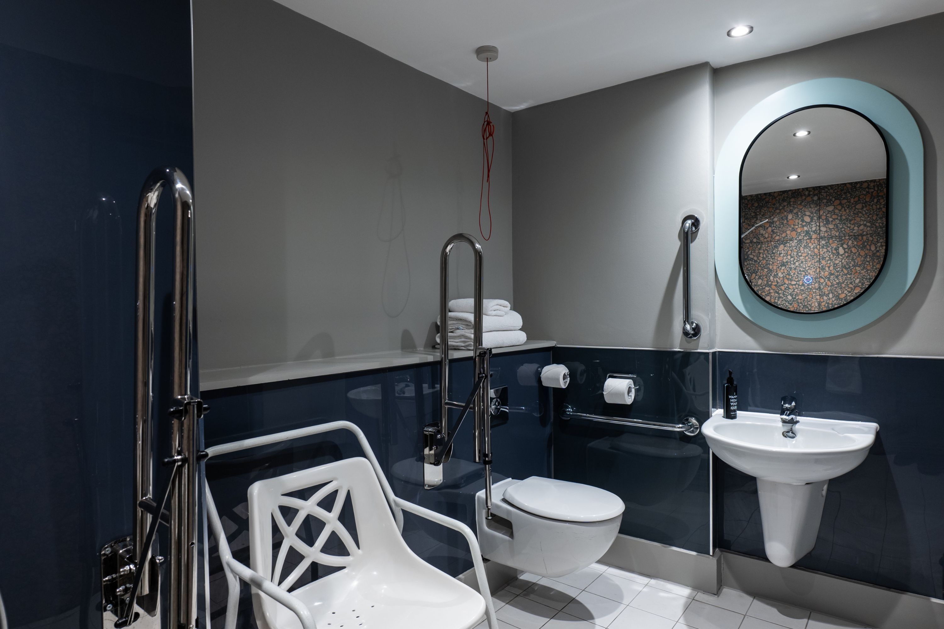 Un baño moderno con inodoro blanco, lavamanos y mampara de vidrio.