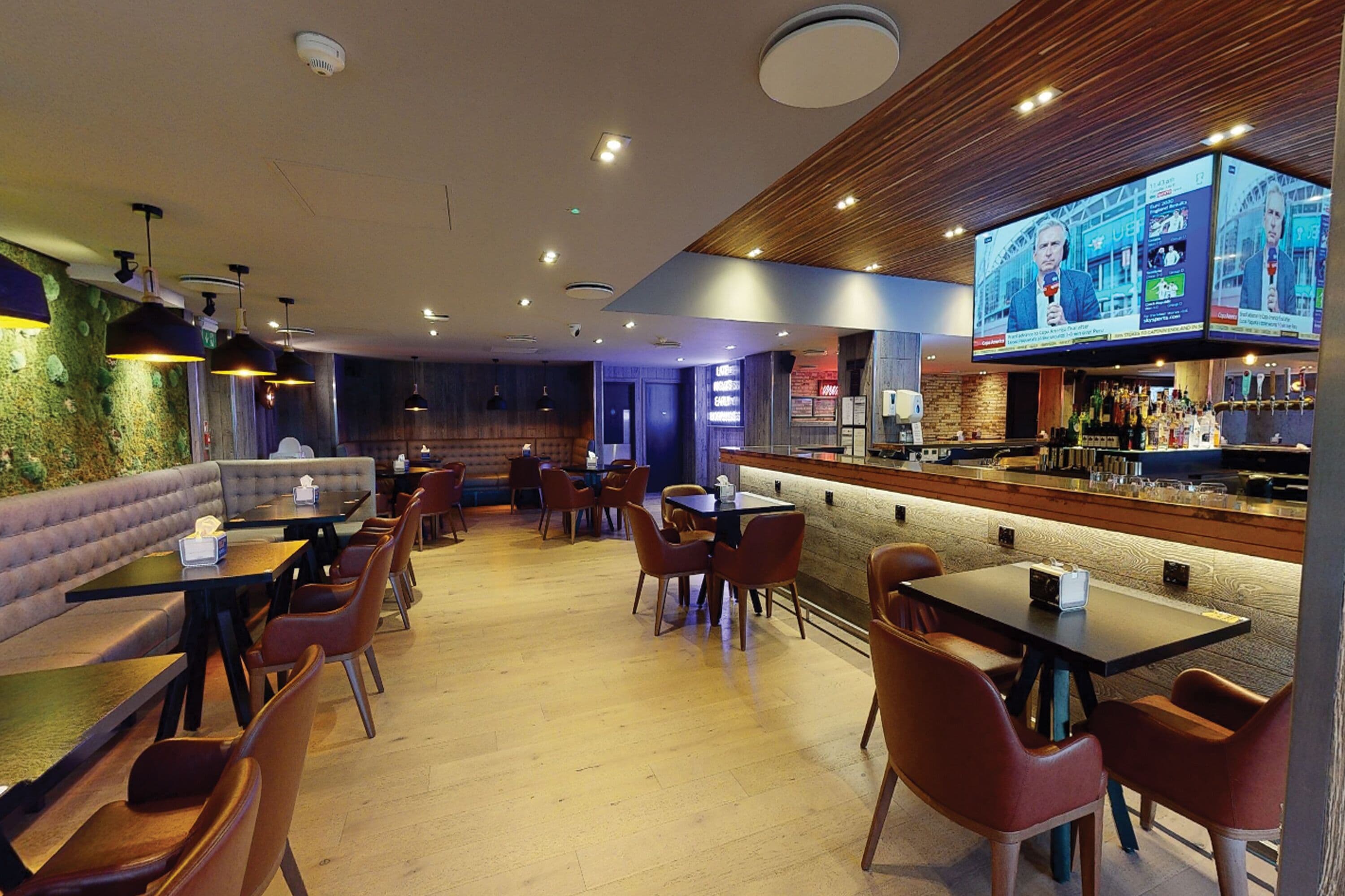 A restaurant with booths, tables, and a bar area.