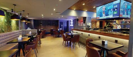A restaurant with booths, tables, and a bar area.