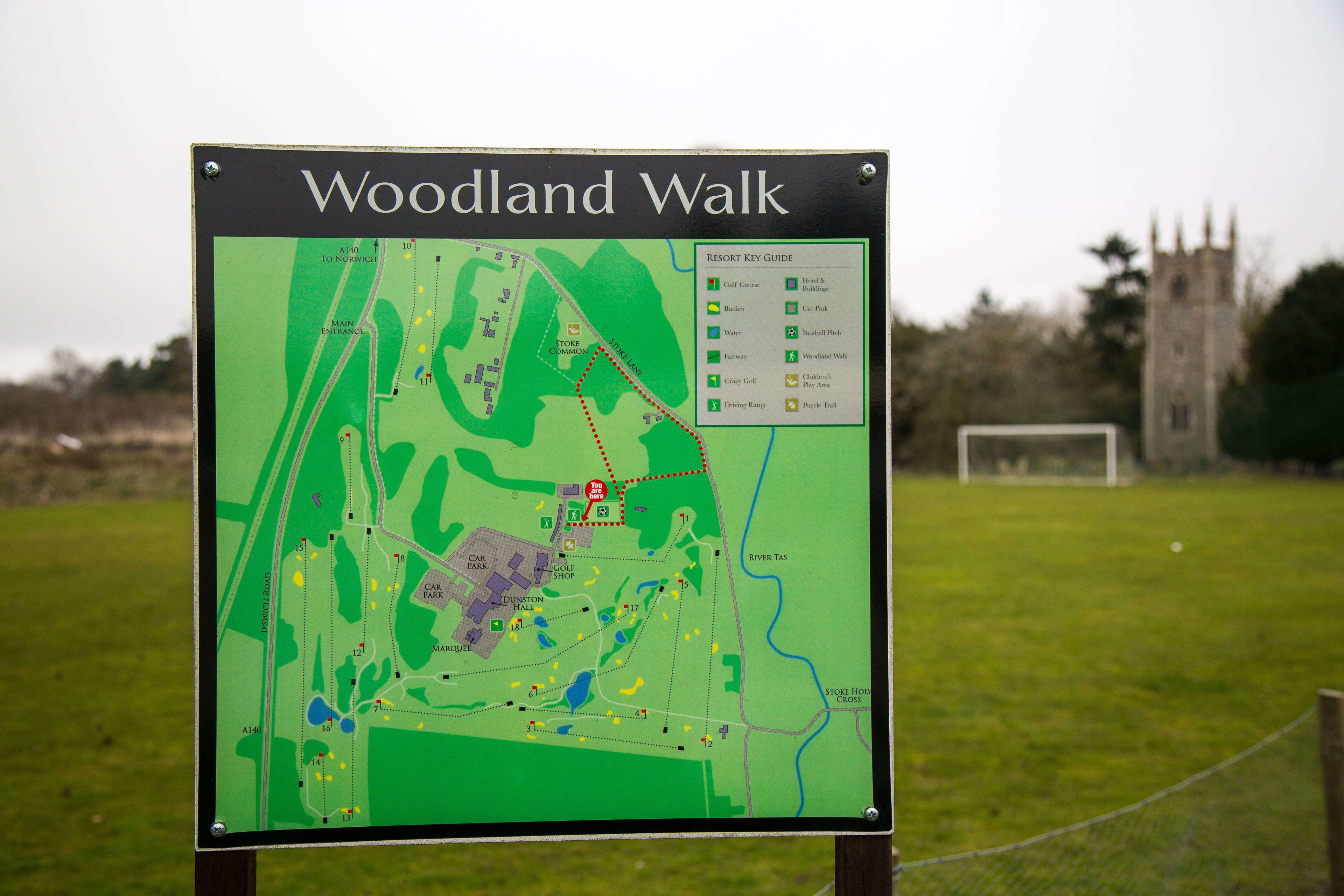Un mapa de Woodland Walk con una guía de acceso al resort, que muestra diversas comodidades como campos de golf, estacionamientos y una tienda de golf.