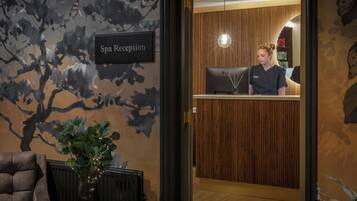 A spa reception area with a reception desk, a computer, and a sign indicating the spa reception.