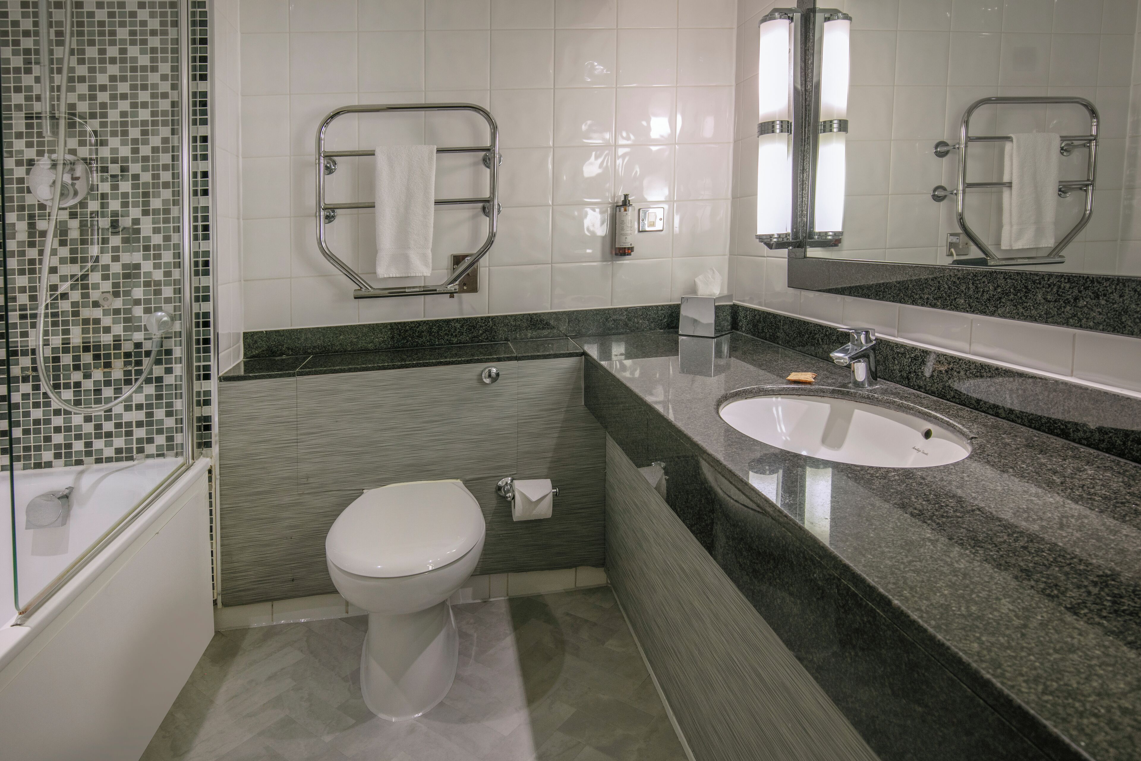 Un baño moderno con inodoro, lavamanos y ducha.