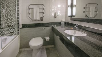 Un baño moderno con inodoro, lavamanos y ducha.