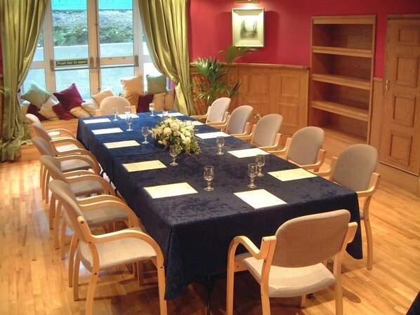 A conference room with a long table, chairs, and a floral centerpiece. - Castle Oaks House Hotel (Castleconnell)