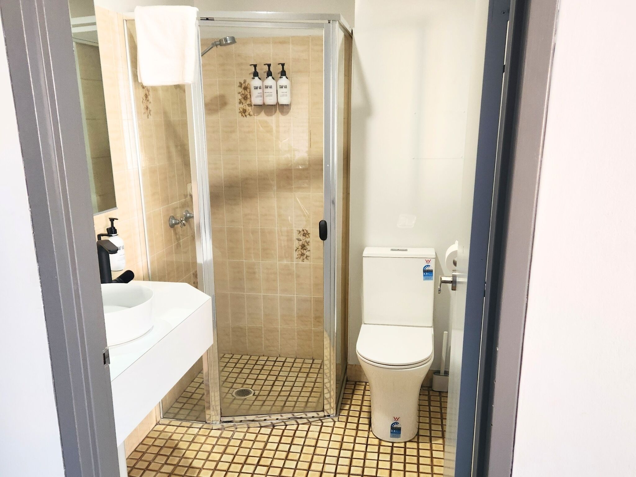 A bathroom with a shower, toilet, and sink.