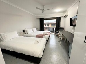 A hotel room with two beds, a desk, a chair, a TV, and a ceiling fan. - Centrepoint Motel Lismore (Lismore)