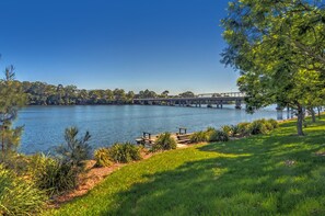 Vista de un lago con un puente, zonas verdes y una mesa de picnic.