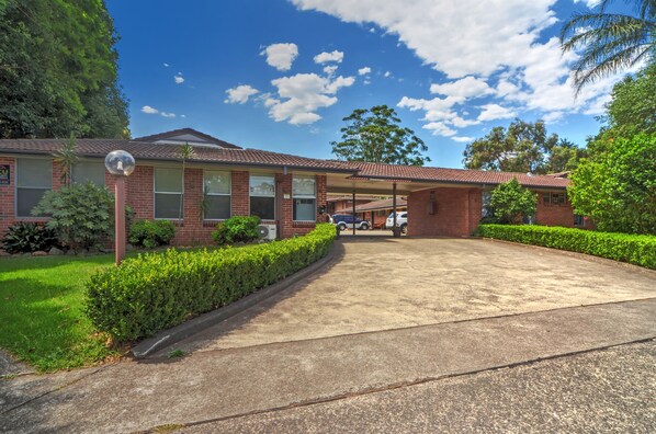 Set amidst well-maintained gardens, this two-story residence offers a driveway and parking area.