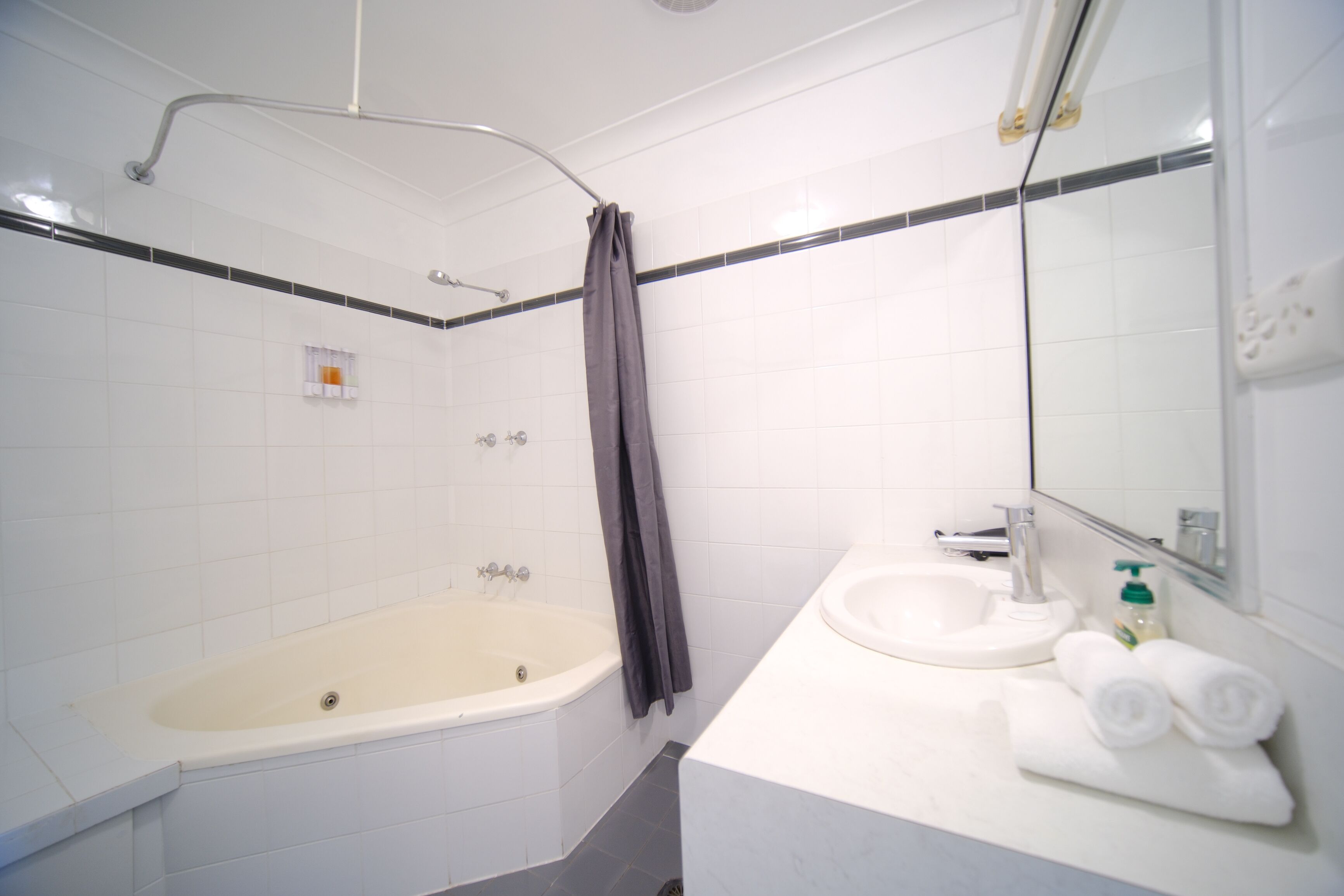 Un baño moderno con bañera, lavabo y espejo.