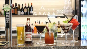 En bardisk med forskellige drikke, heriblandt en øl, en cocktail og en dessertdrik.