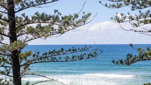 A coastal view with a wooden walkway, beach, and ocean. - Beach Retreat Coolum (Coolum Beach)