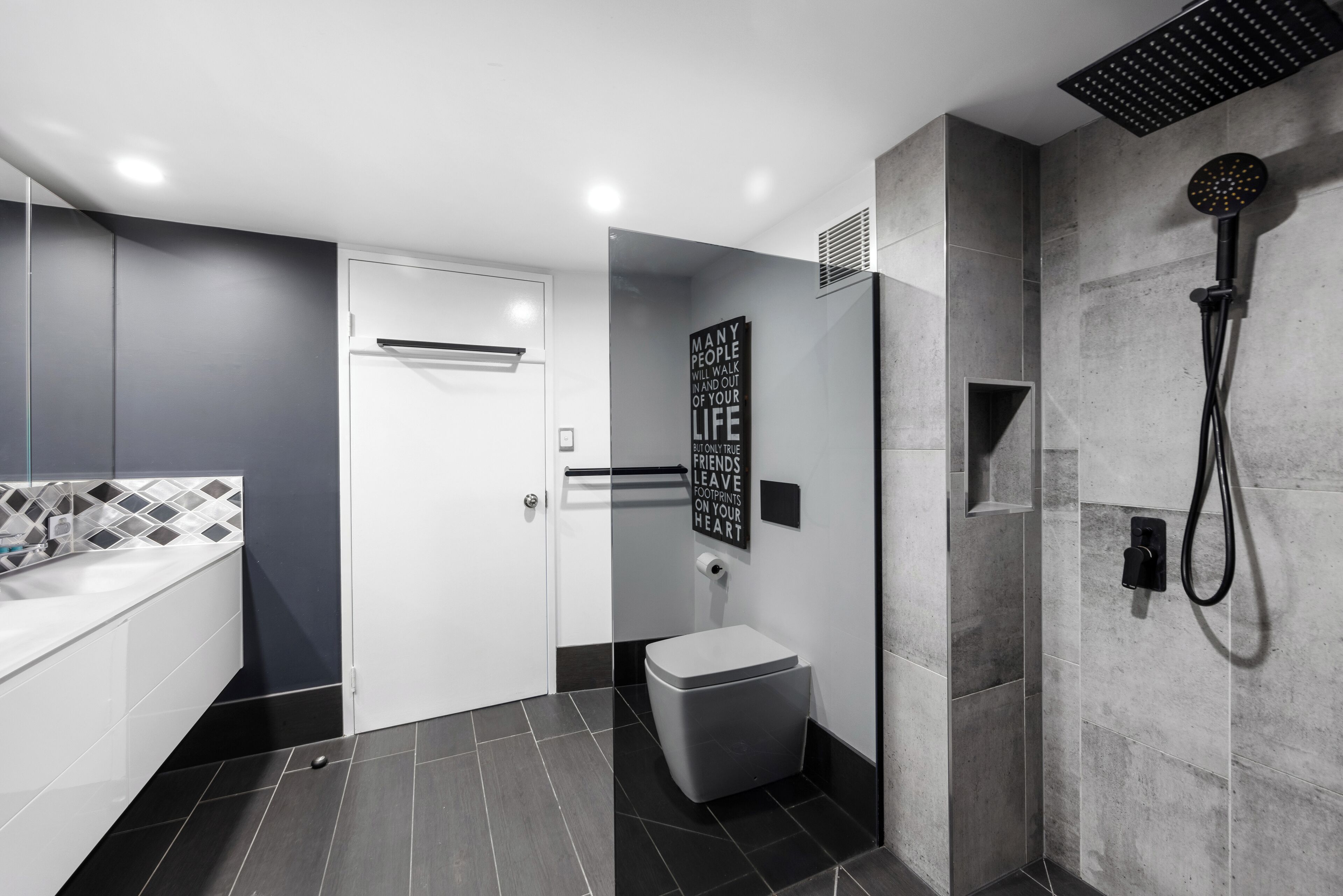 Et moderne badeværelse med bruser, toilet og badekar.