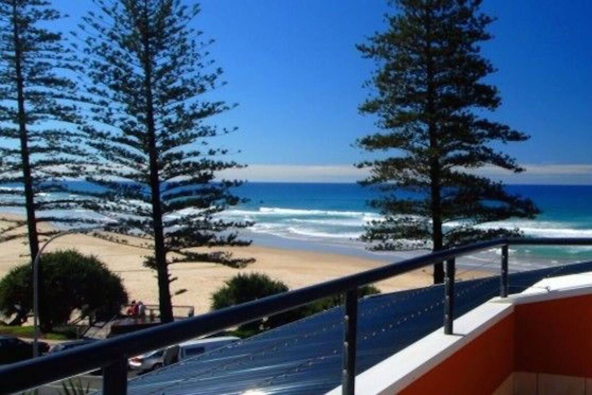 A balcony with a view of a beach and ocean.