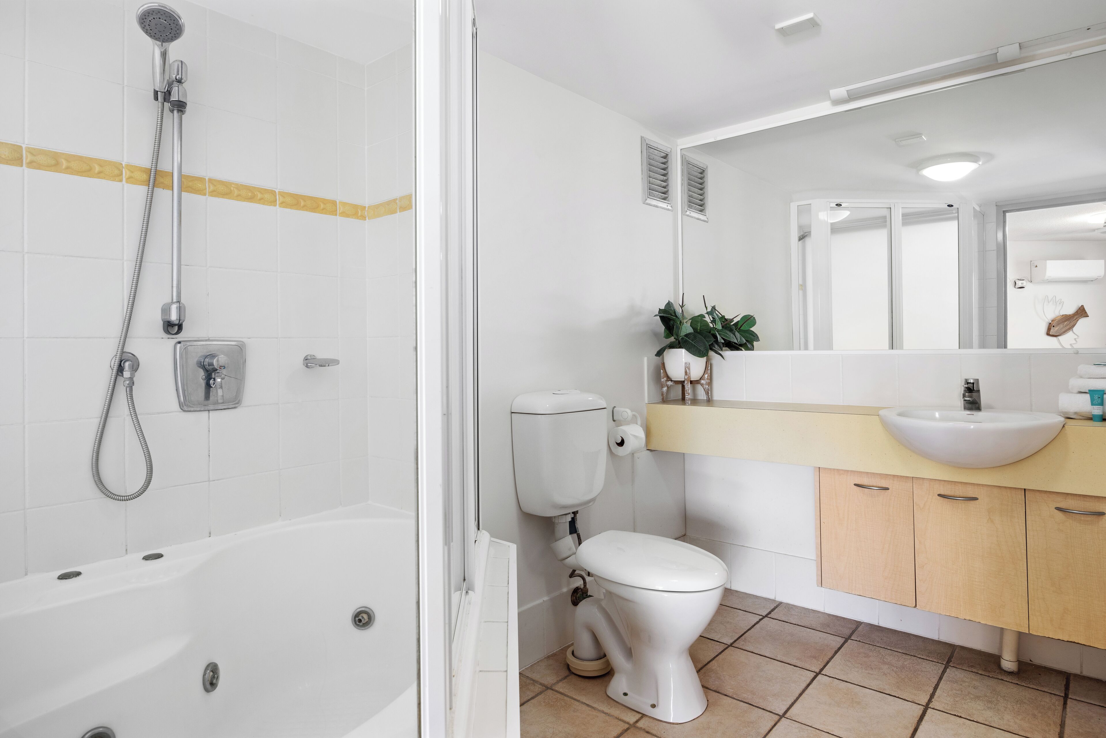A modern bathroom with a bathtub, toilet, and sink.