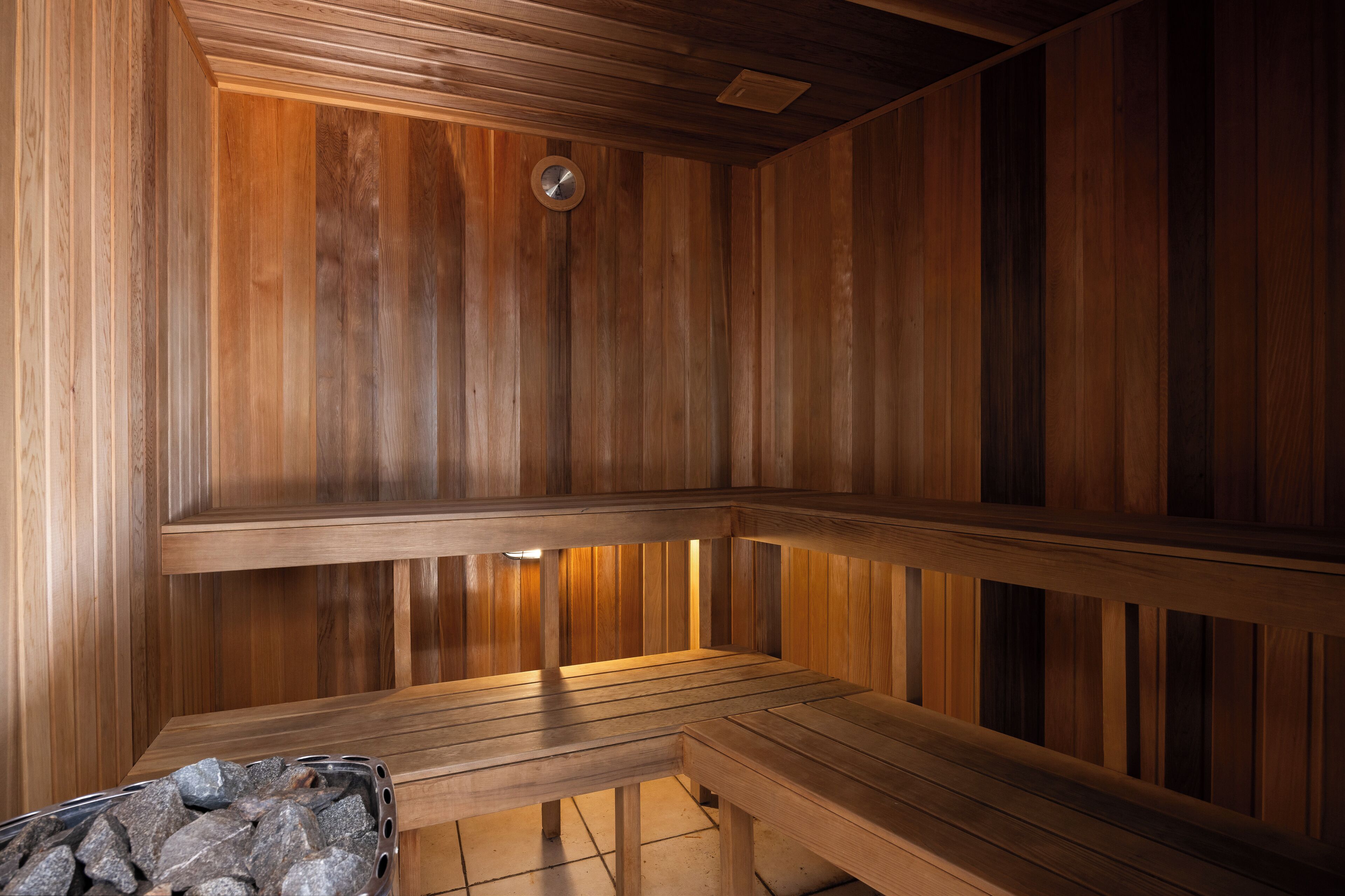 A wooden sauna with benches and a stone basin.