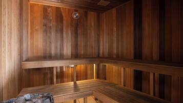 A wooden sauna with benches and a stone basin.