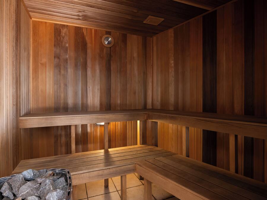 A wooden sauna with benches and a stone basin.