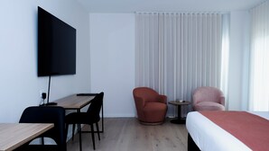 A hotel room with a bed, a desk, two chairs, a TV, and a window with curtains. - Keith Motor Inn (Keith)
