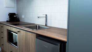 A modern kitchen with a stainless steel sink, a built-in oven, and a dishwasher. - Keith Motor Inn (Keith)