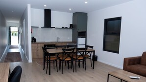 A modern kitchen with a dining area, a sofa, and a coffee table. - Keith Motor Inn (Keith)