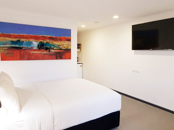 A hotel room with a bed, a painting, a television, and a small cabinet. - William Macintosh Motor Lodge (Naracoorte)