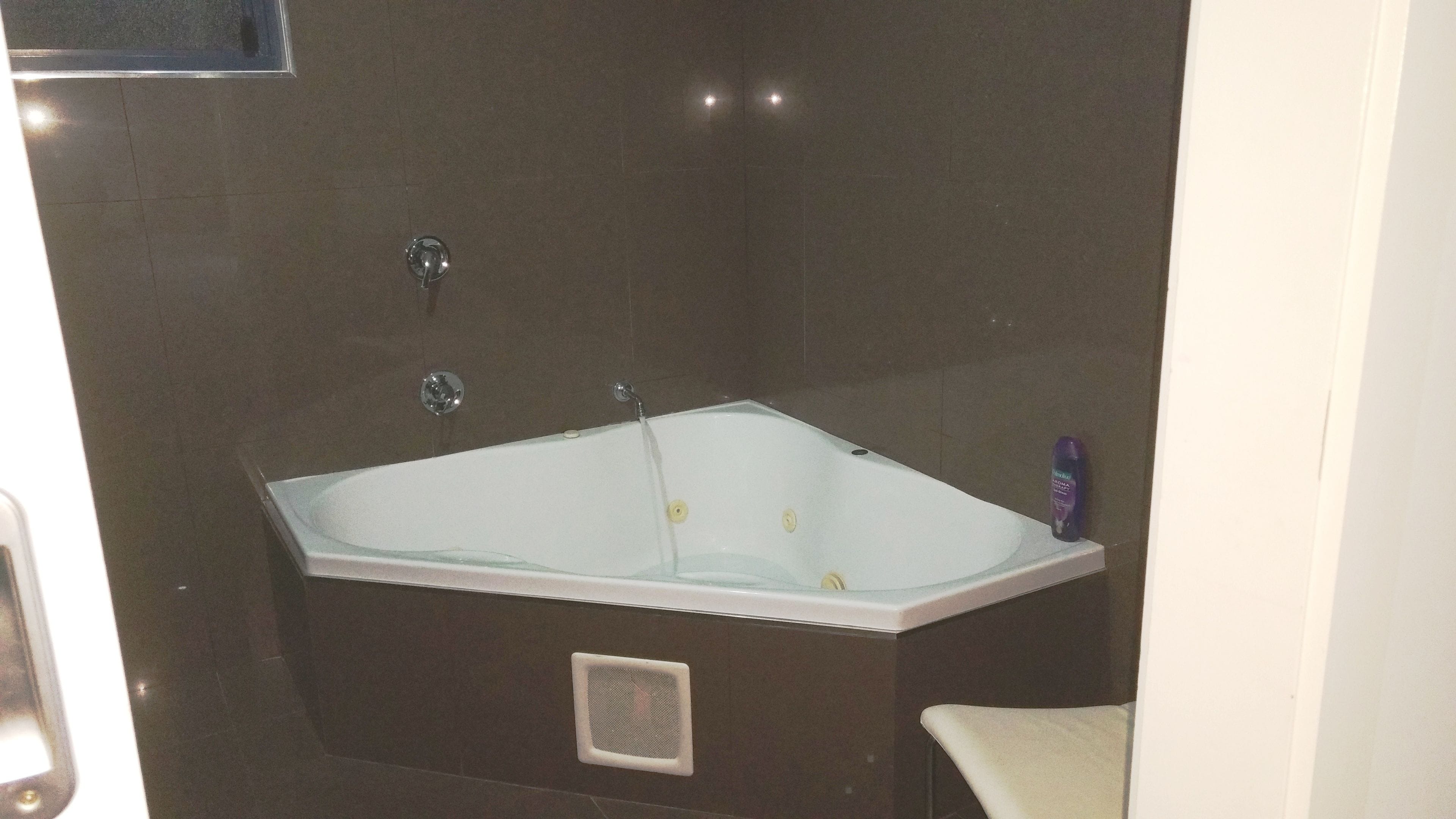 A modern bathroom with a freestanding bathtub, a showerhead, and a handheld shower.