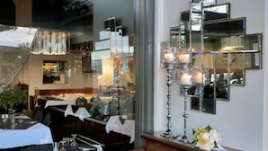 Un interior de restaurante con una larga mesa de comedor, sillas y una araña.