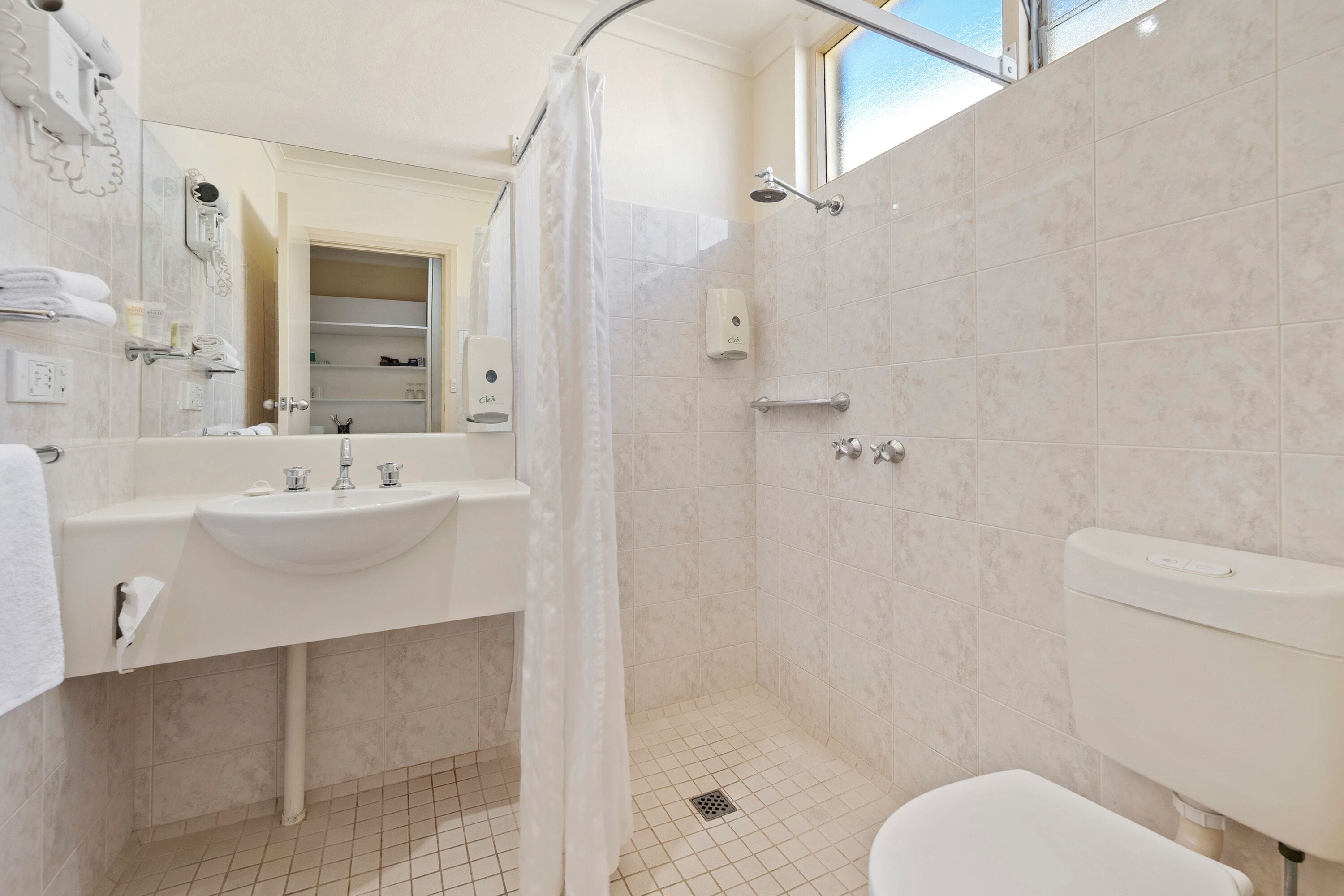 A modern bathroom with a sink, toilet, and shower.