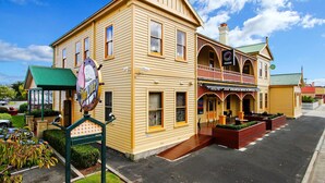 A yellow building with a balcony and a sign that reads "QASIS".